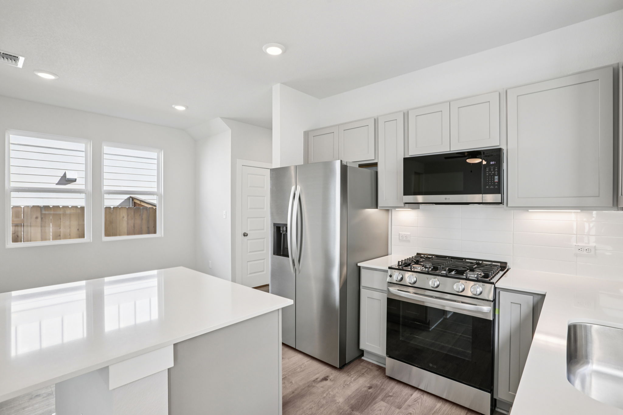 A kitchen with white cabinets.