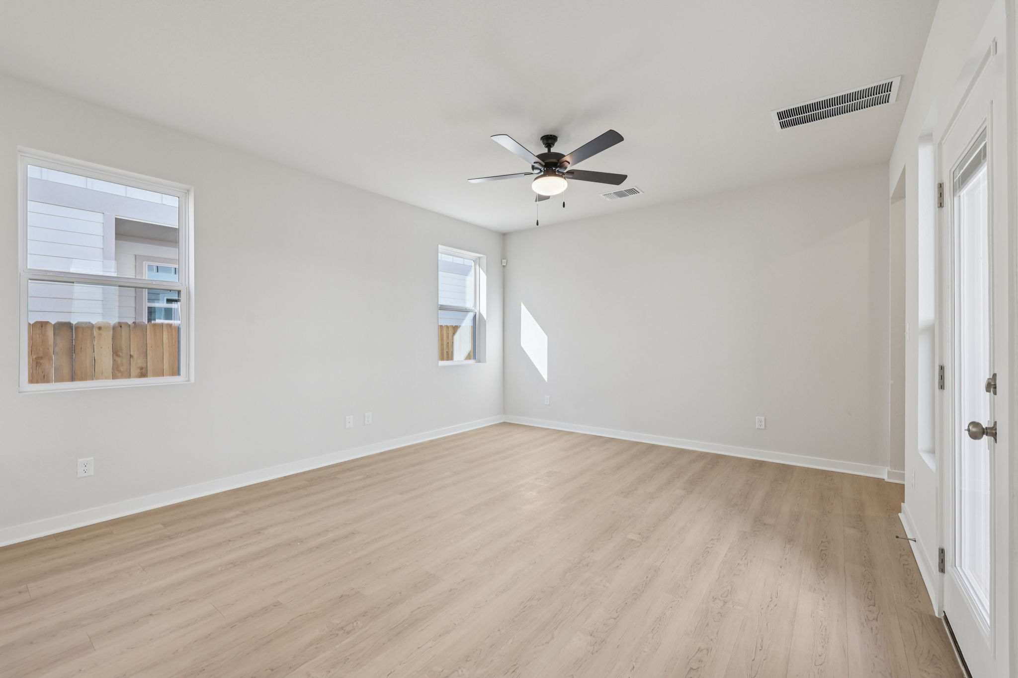 A room with a wood floor and a ceiling fan.