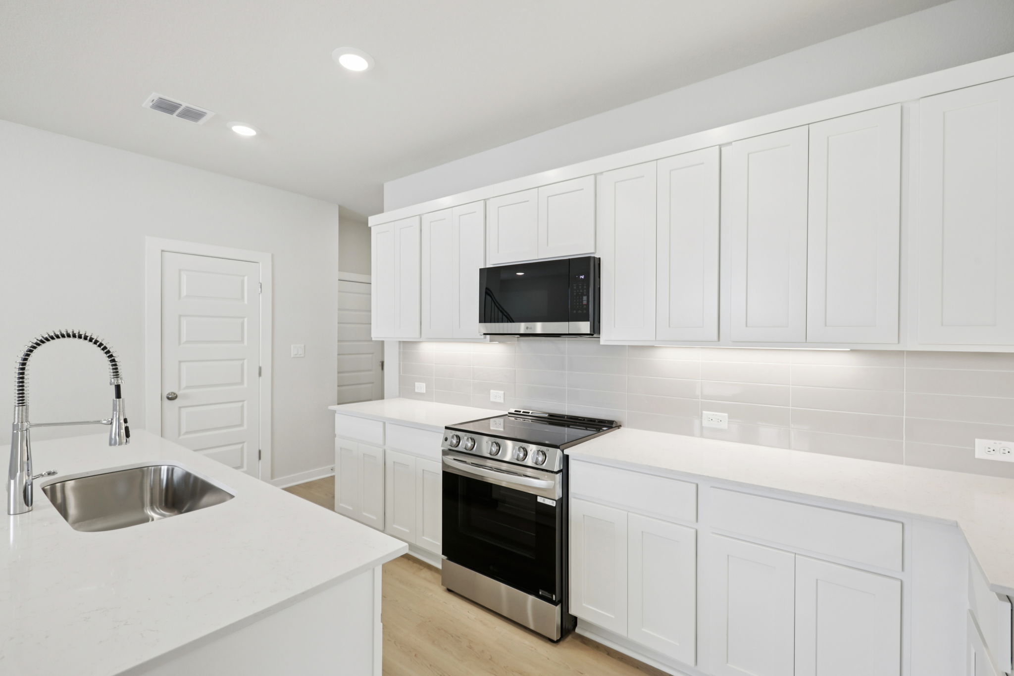 A kitchen with white cabinets.