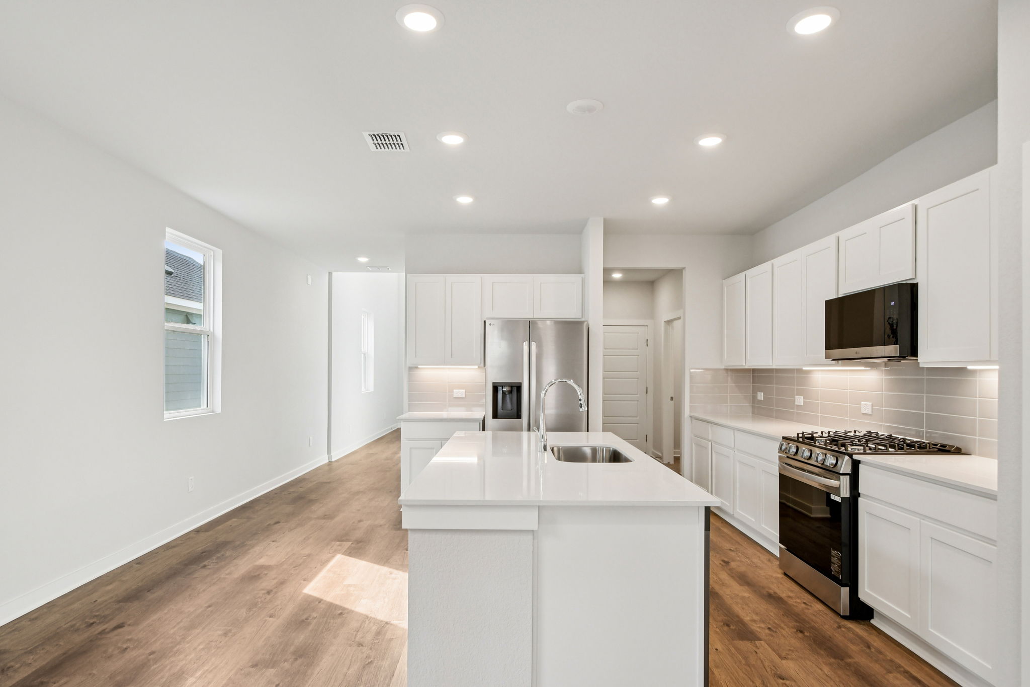 A kitchen with white cabinets.