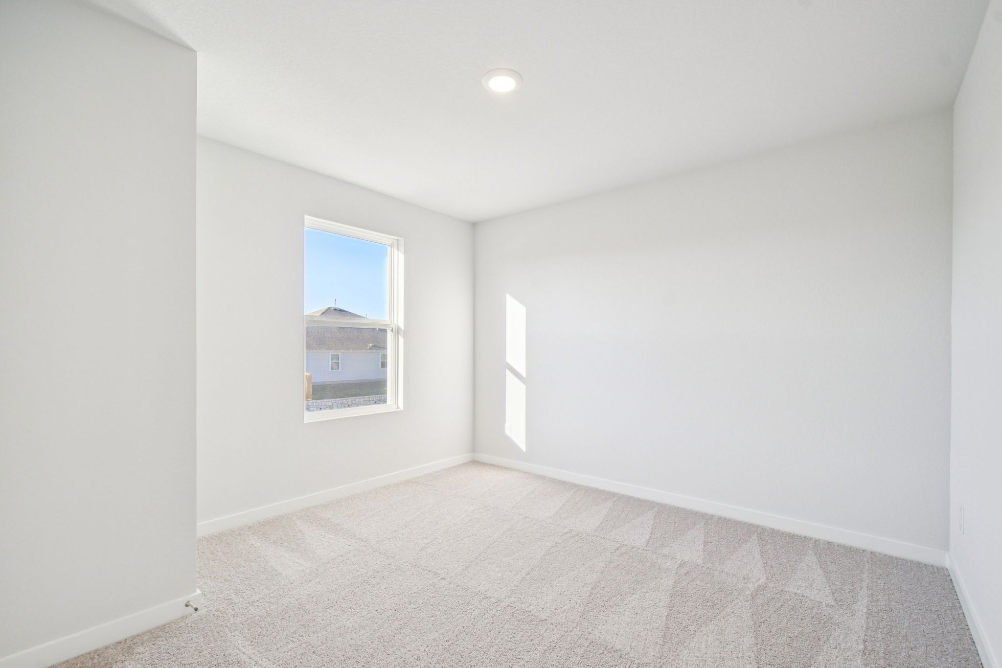 A room with a carpet and a window.