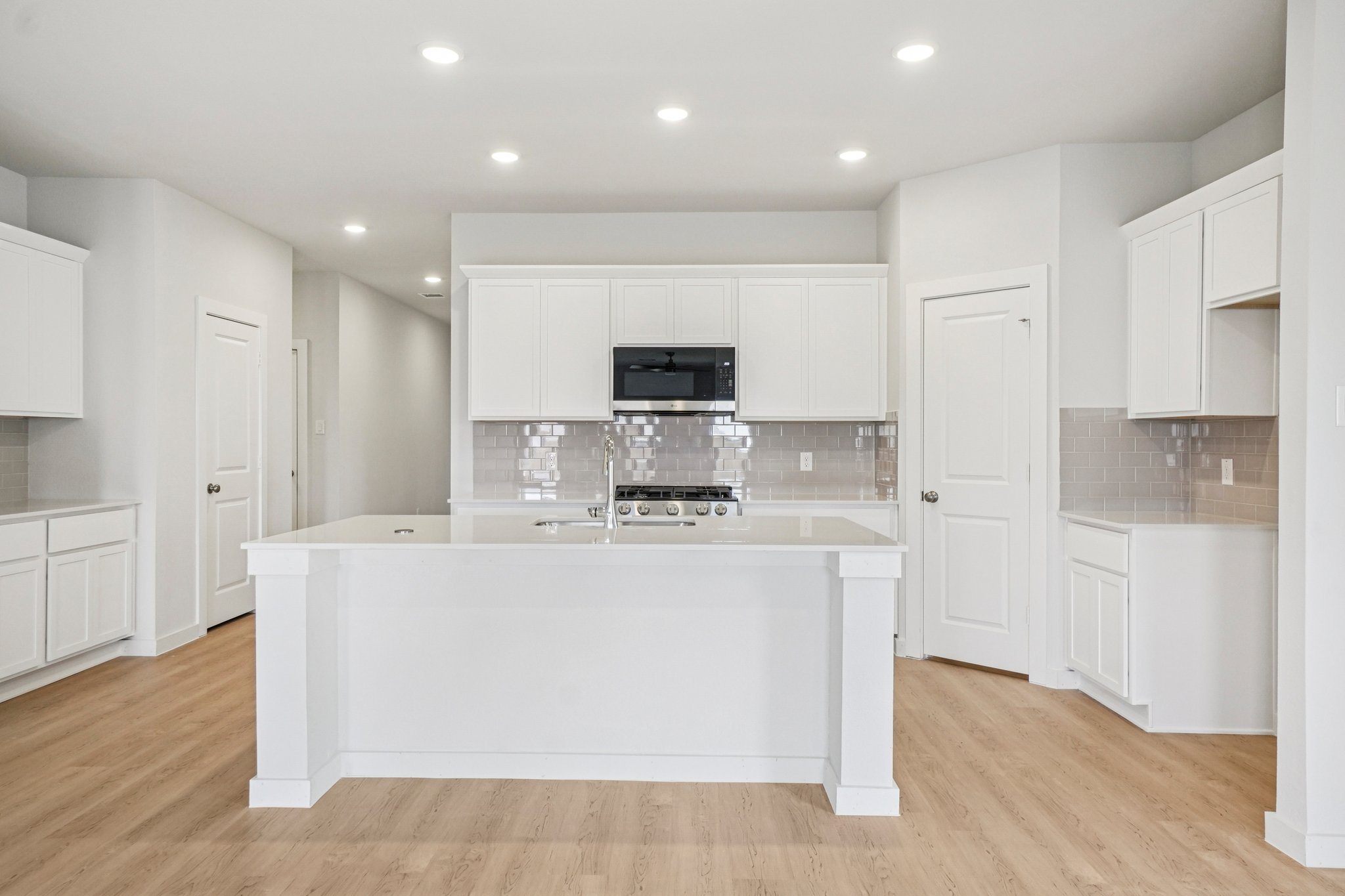 A kitchen with white cabinets.