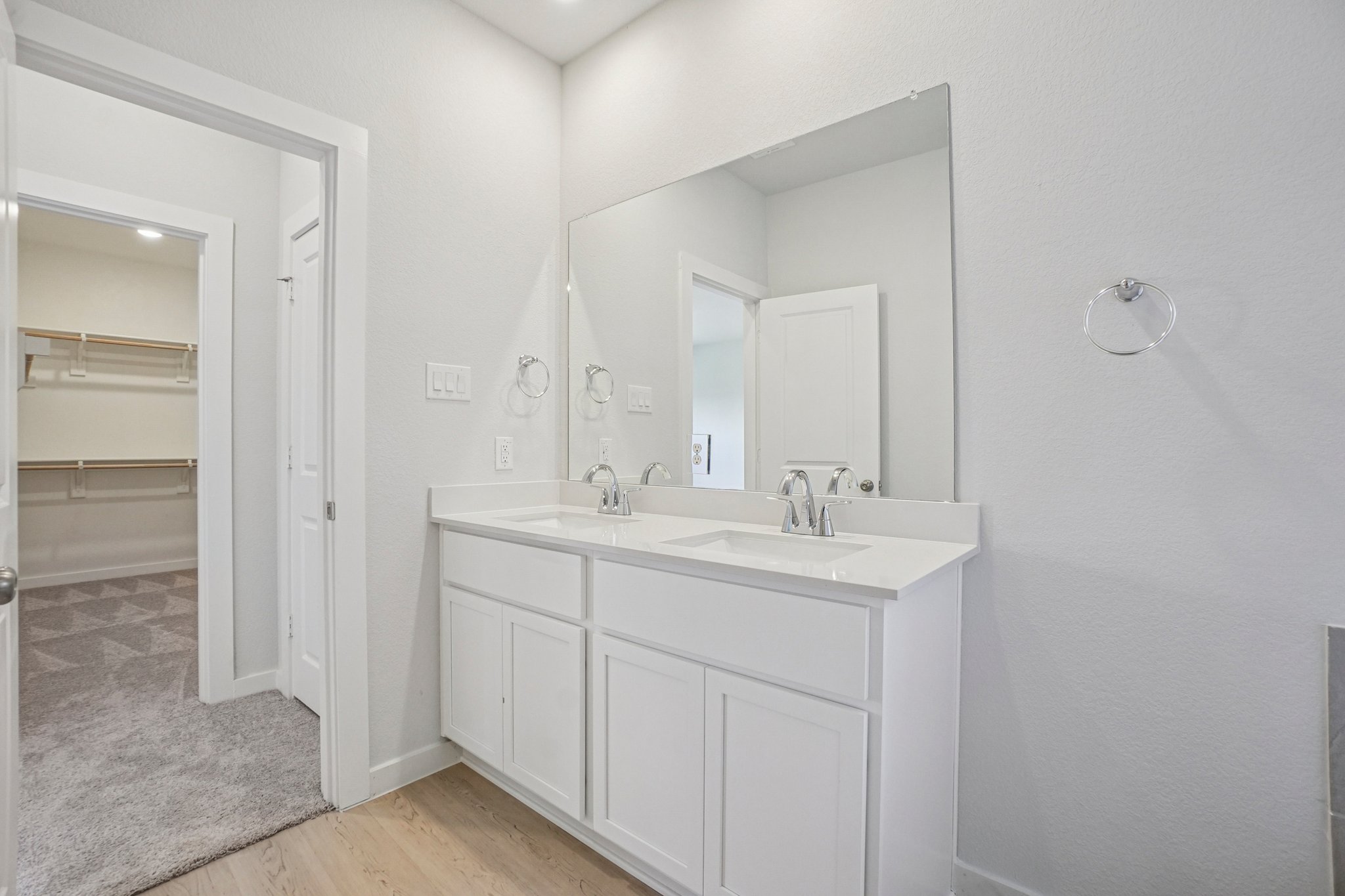 A bathroom with white cabinets.
