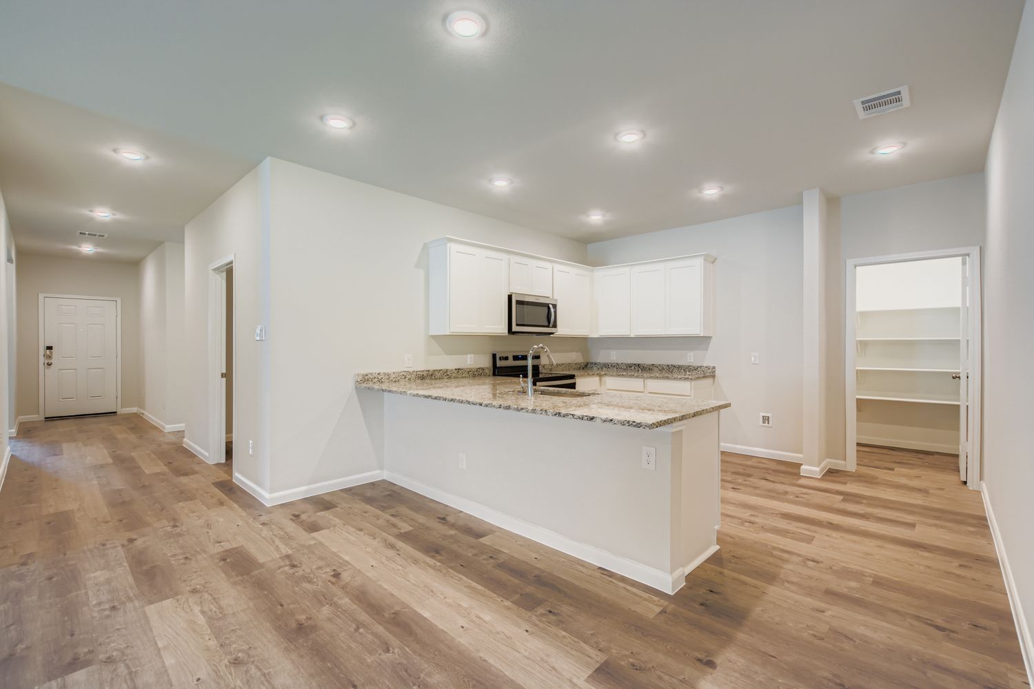 A kitchen with white cabinets.