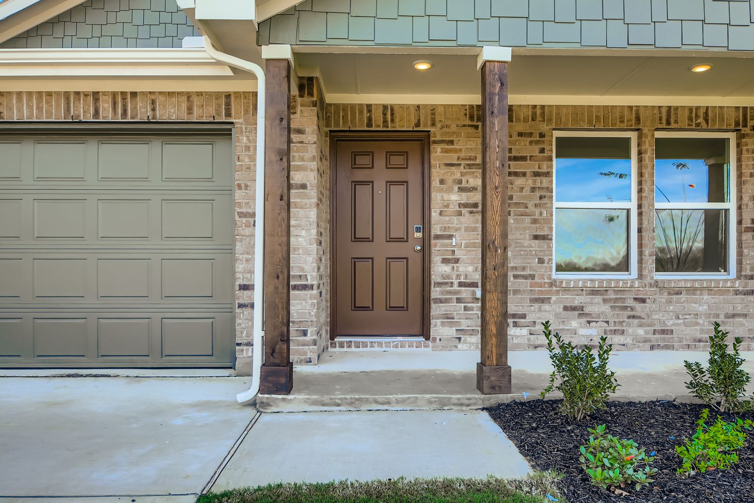 A building with a couple of garage doors and a brick walkway.