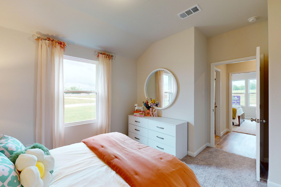 A bedroom with a large mirror.
