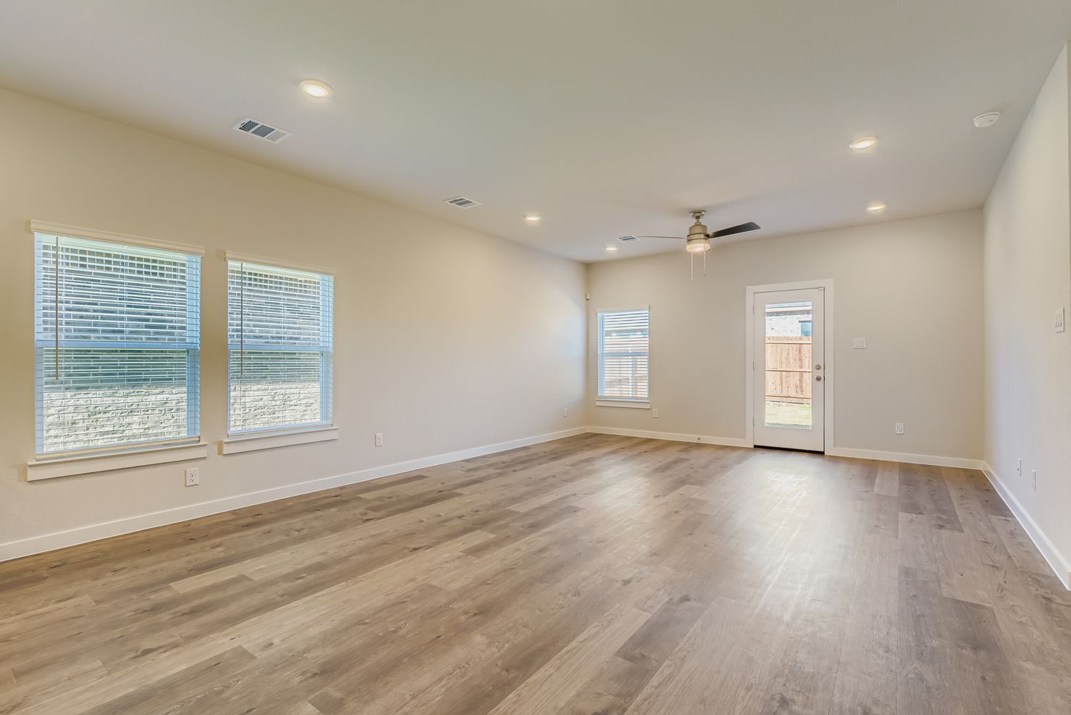 A room with a wood floor and a ceiling fan.