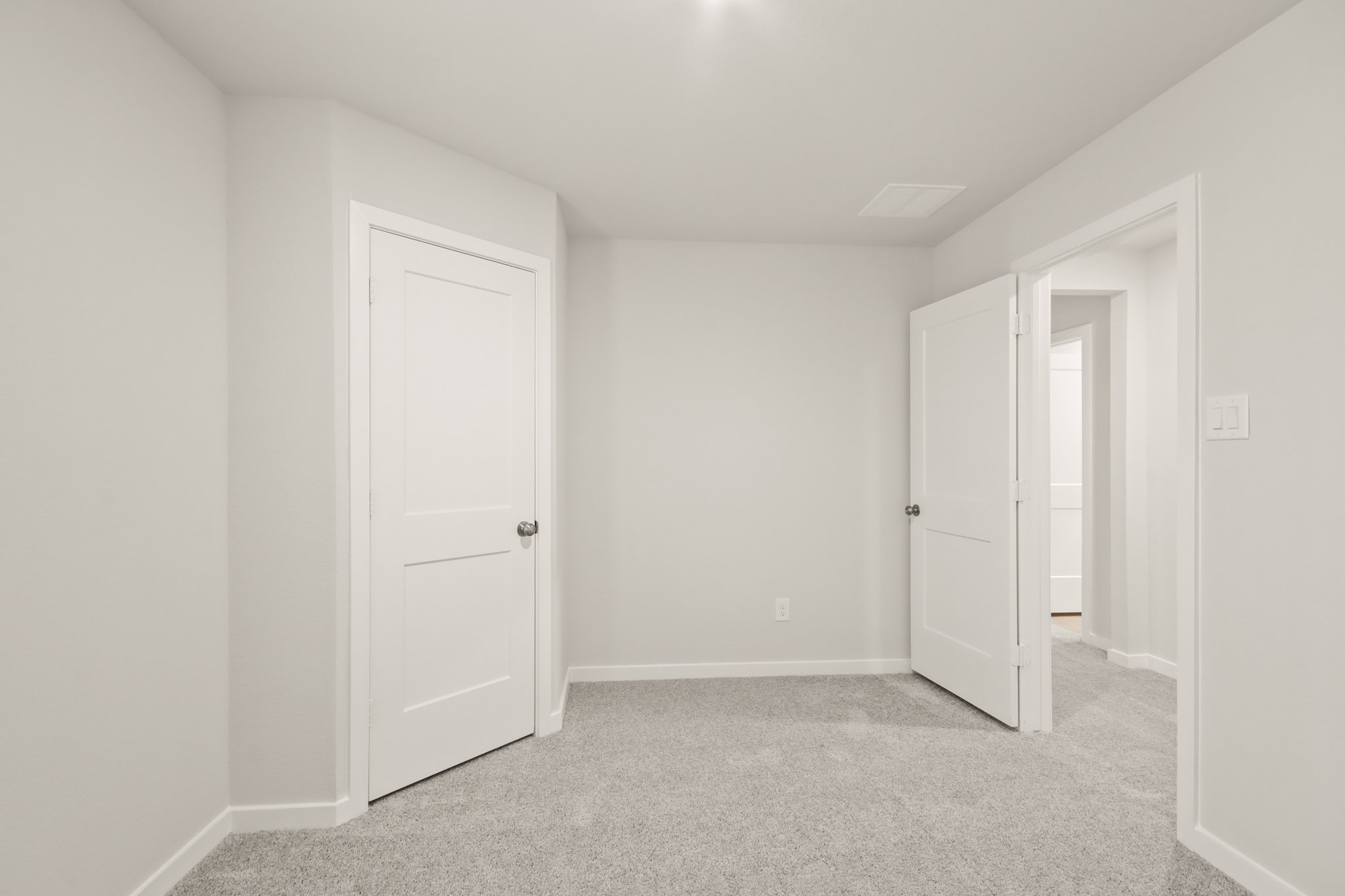 A hallway with white doors.