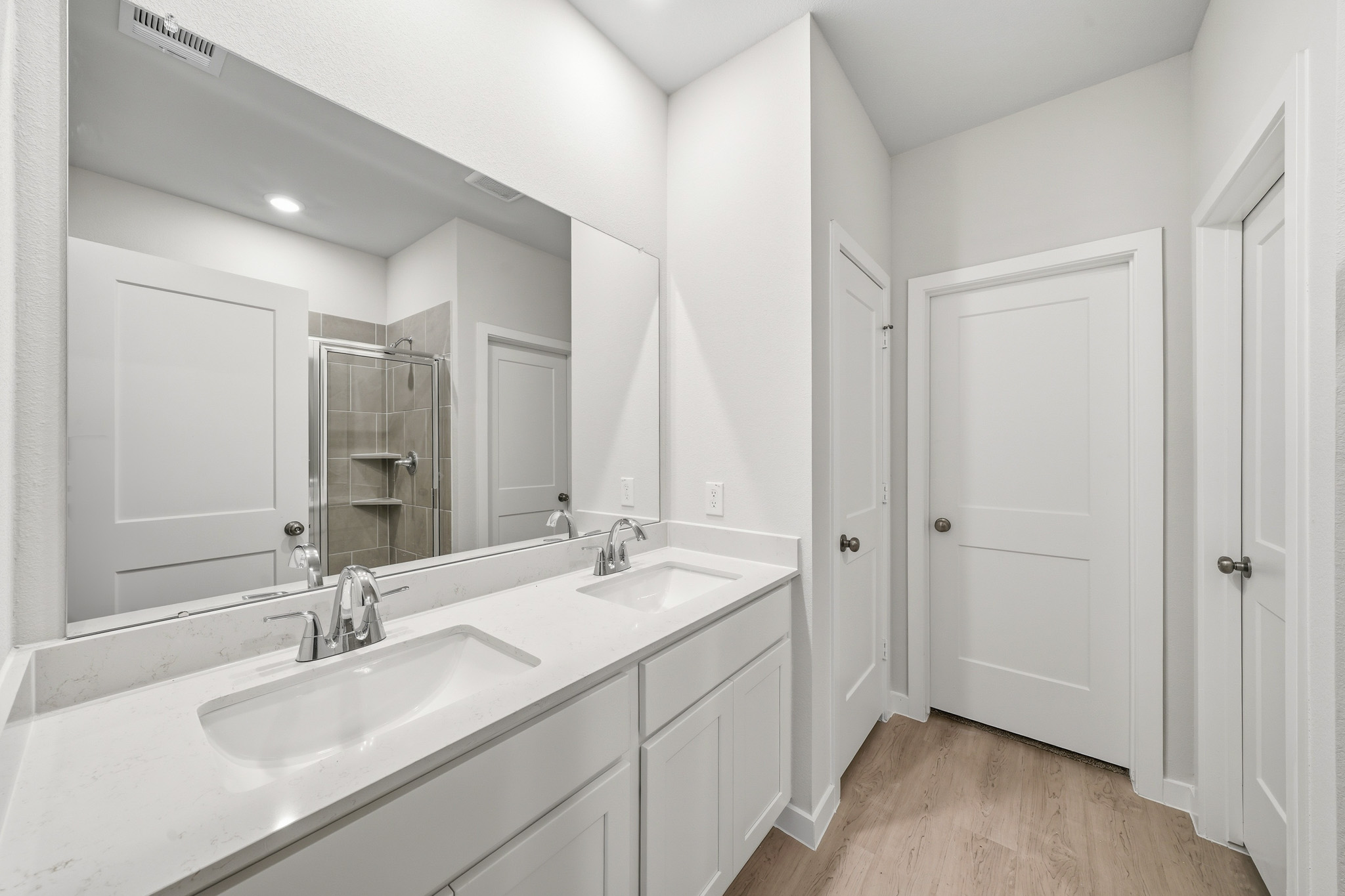 A bathroom with white cabinets.
