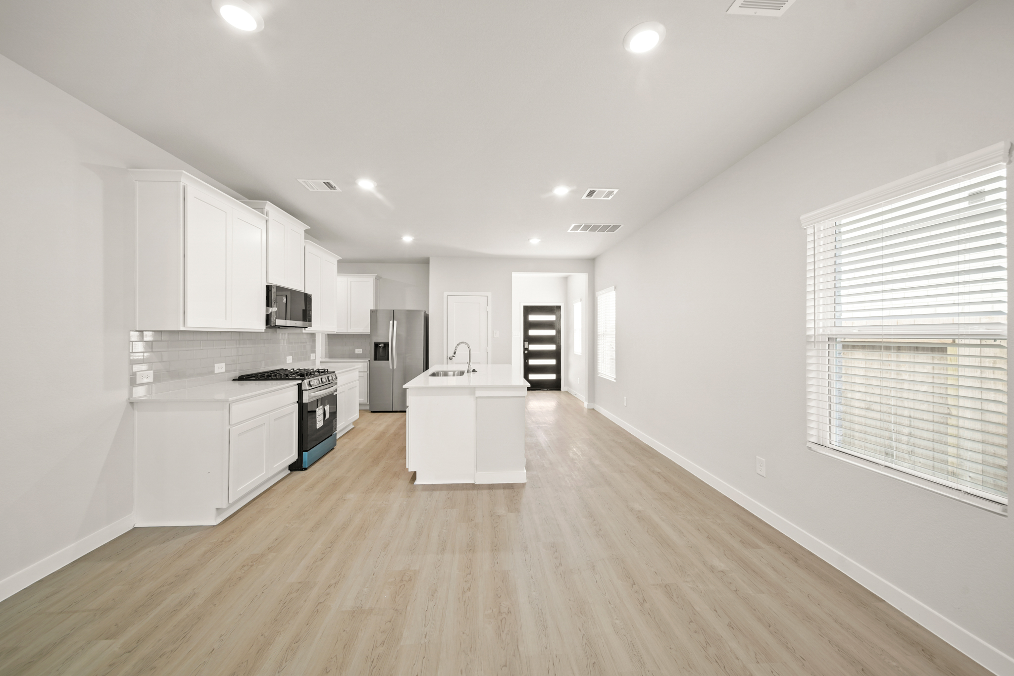 A kitchen with white cabinets.