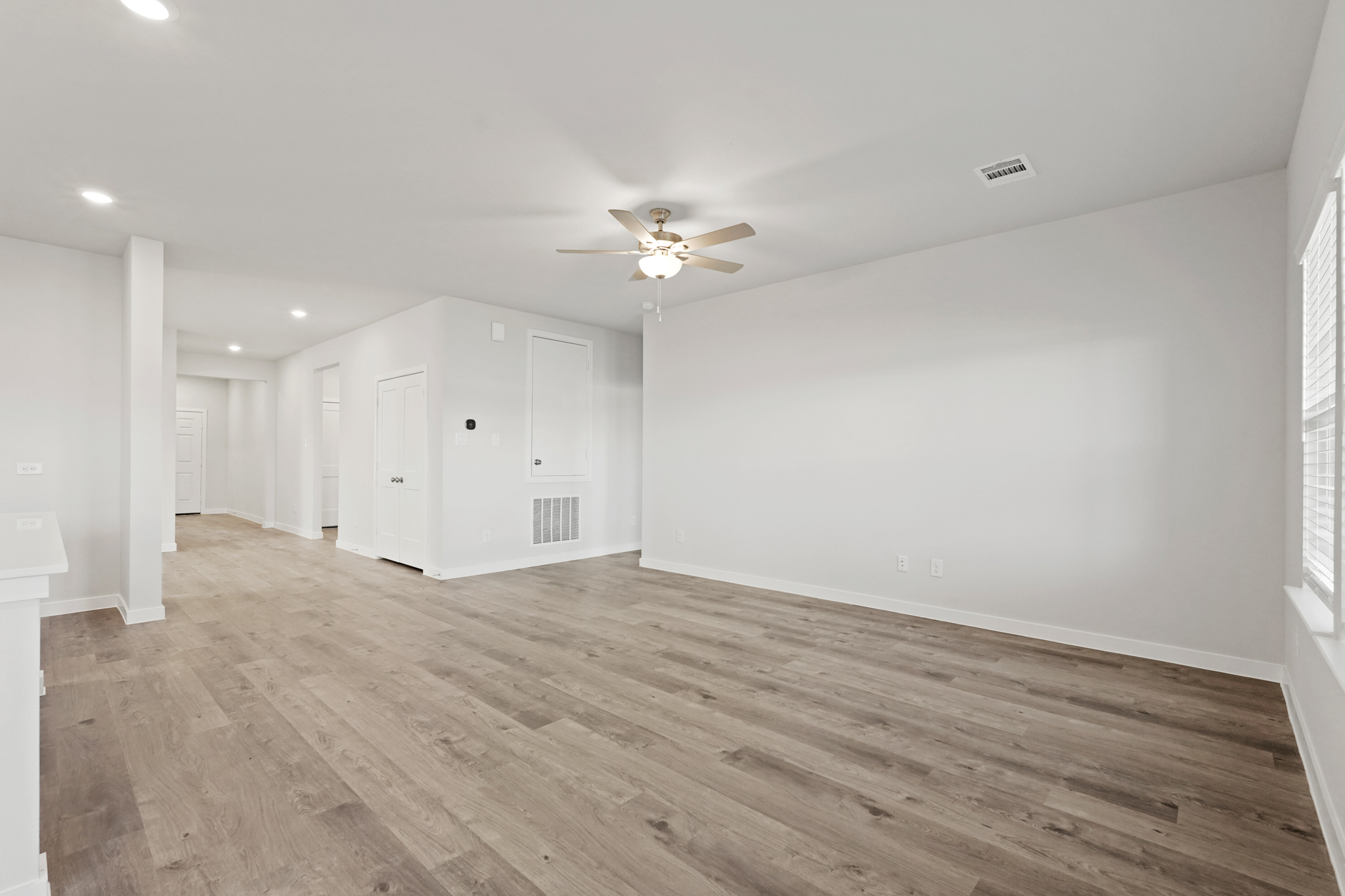 A room with a wood floor and a ceiling fan.
