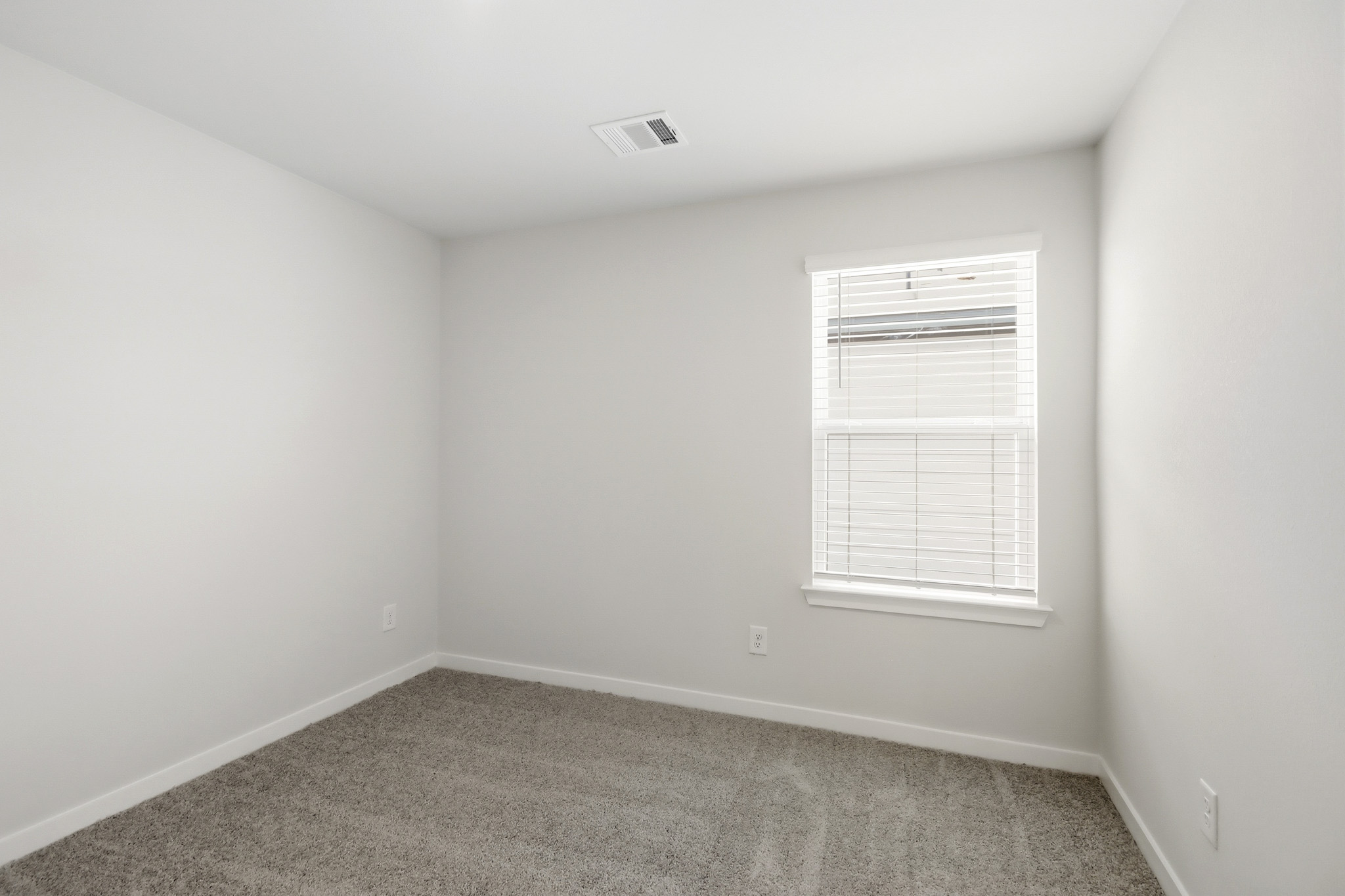 A room with a window and a carpet.