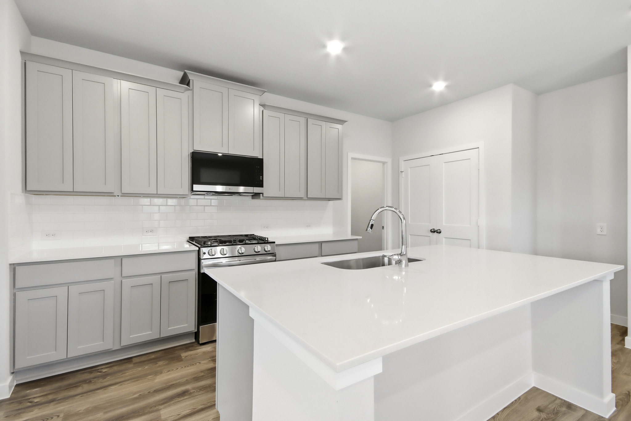 A kitchen with white cabinets.