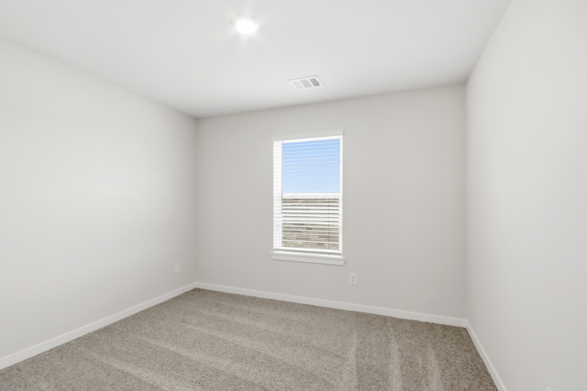 A room with a window and carpet.