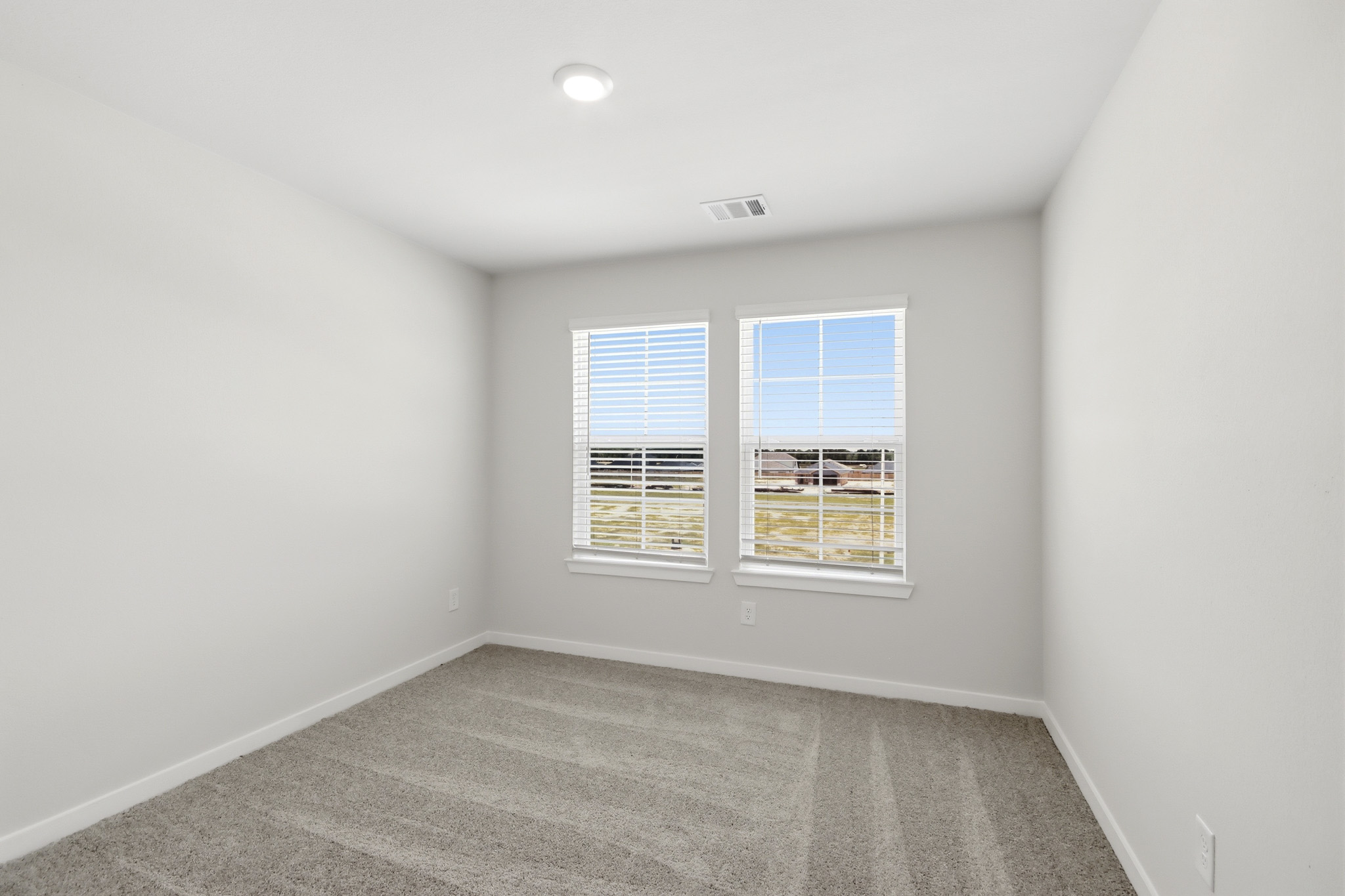 A room with a window and a carpet.