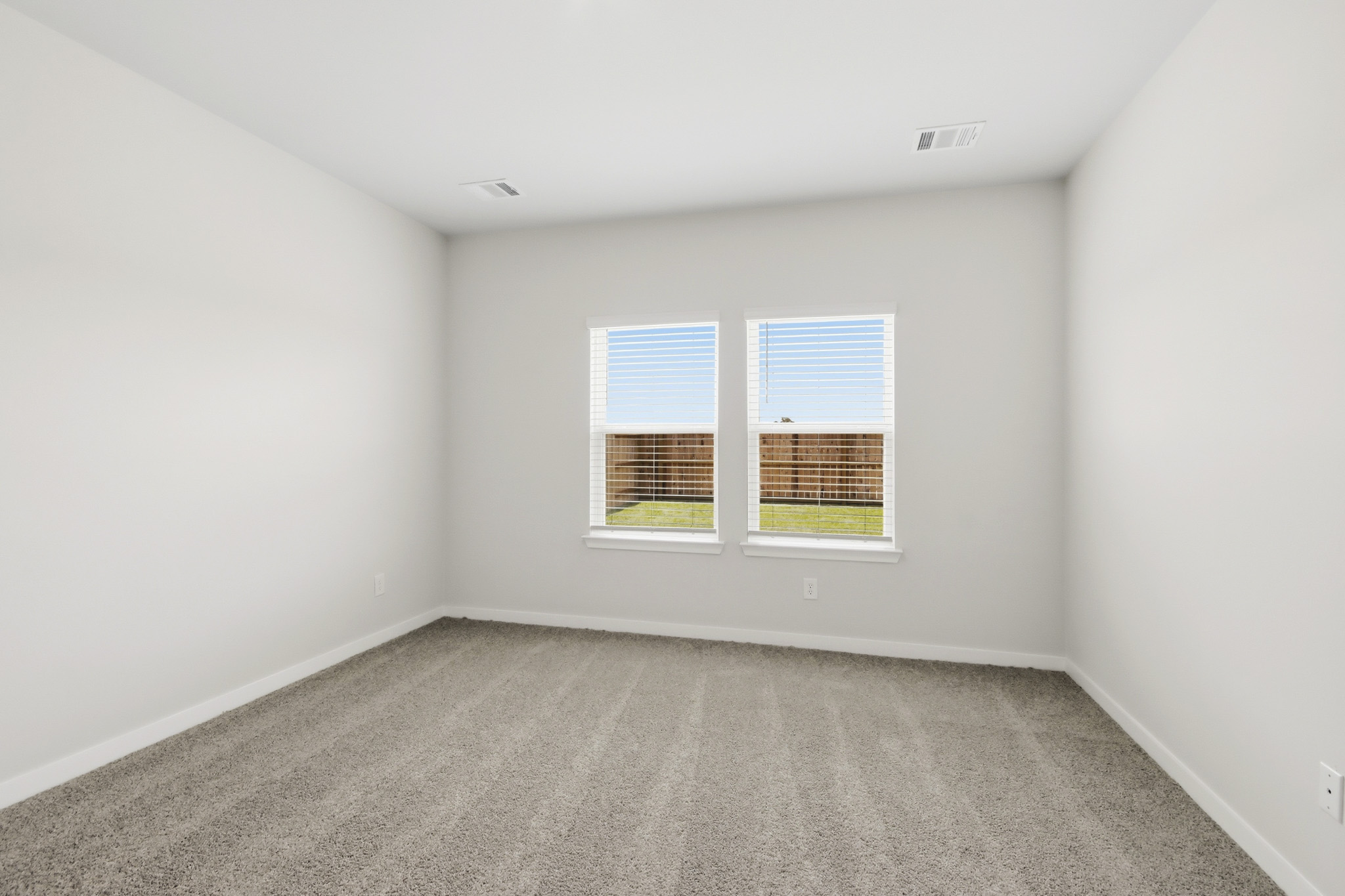 A room with a window and carpet.