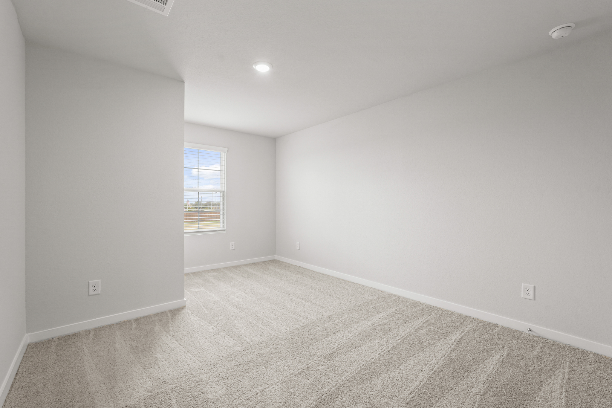 A room with a window and a carpet.