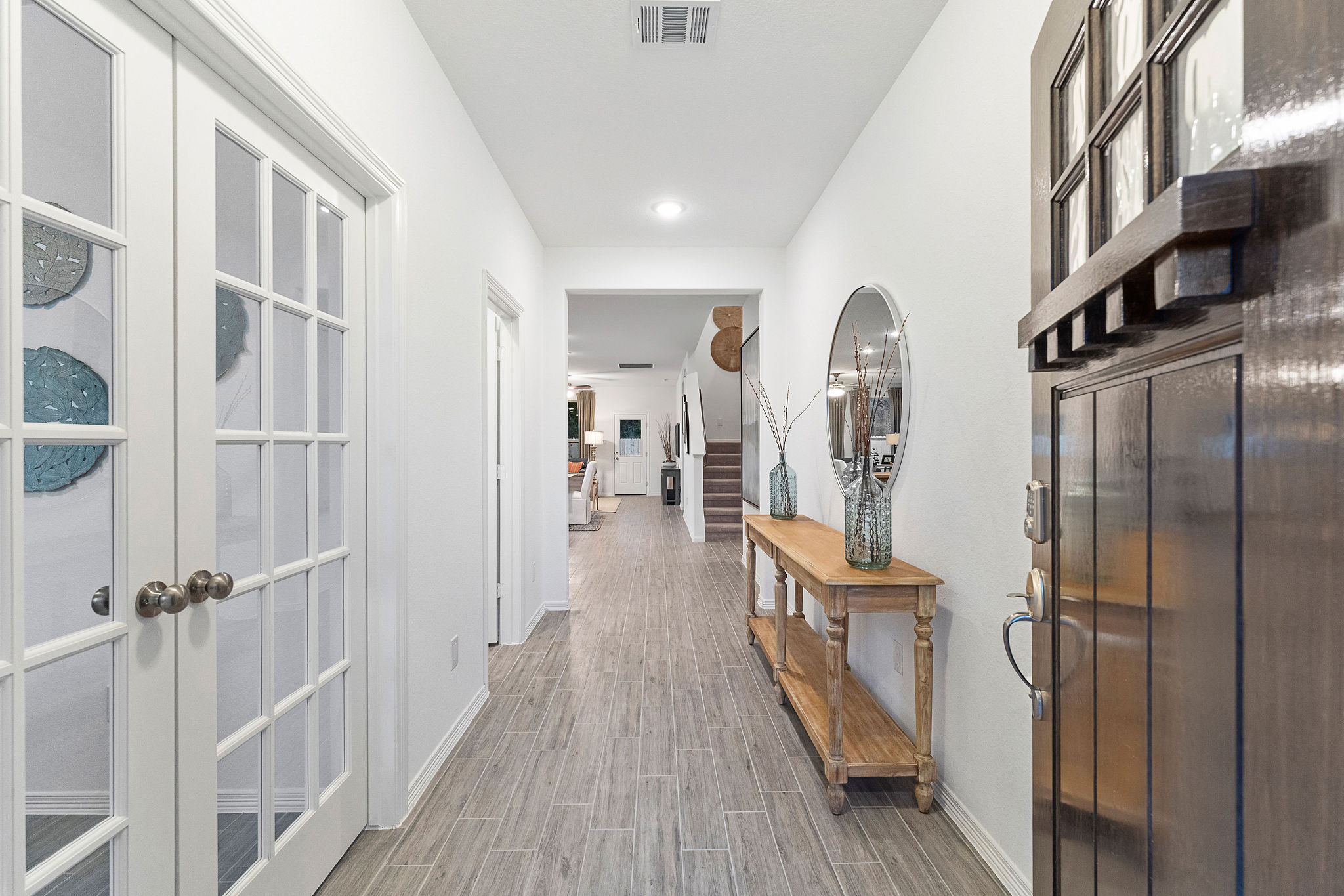 A long hallway with white doors.