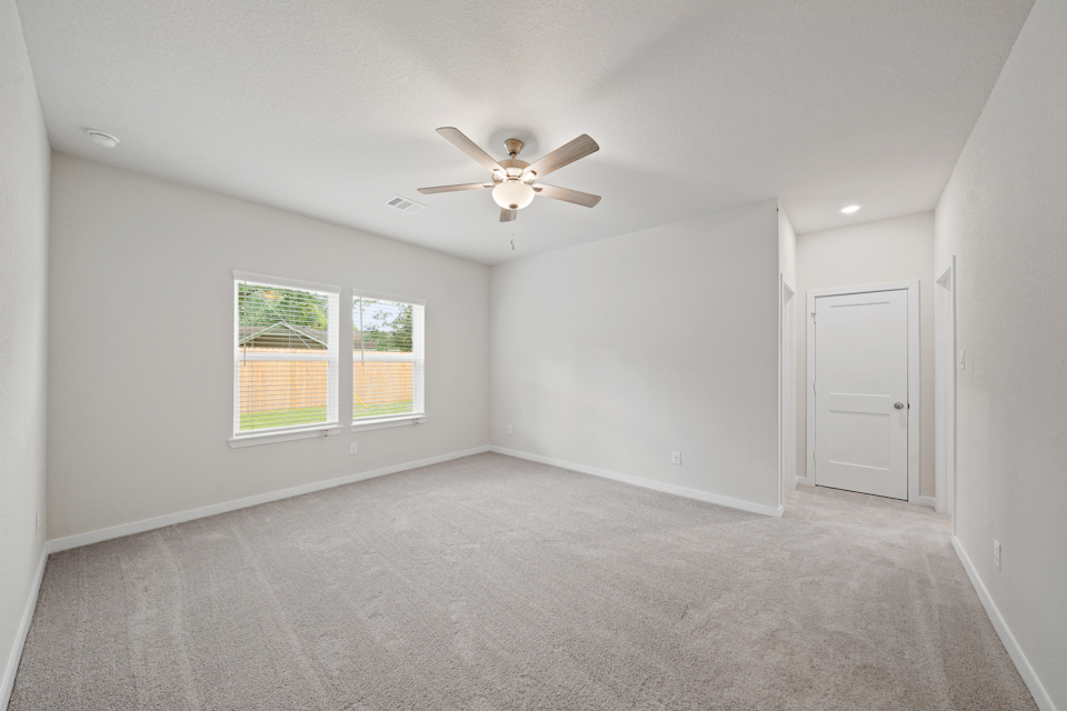 A room with a ceiling fan and a window.