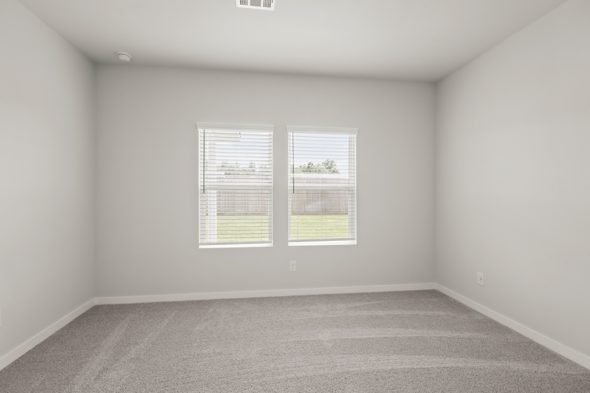 A room with a window and a carpet.