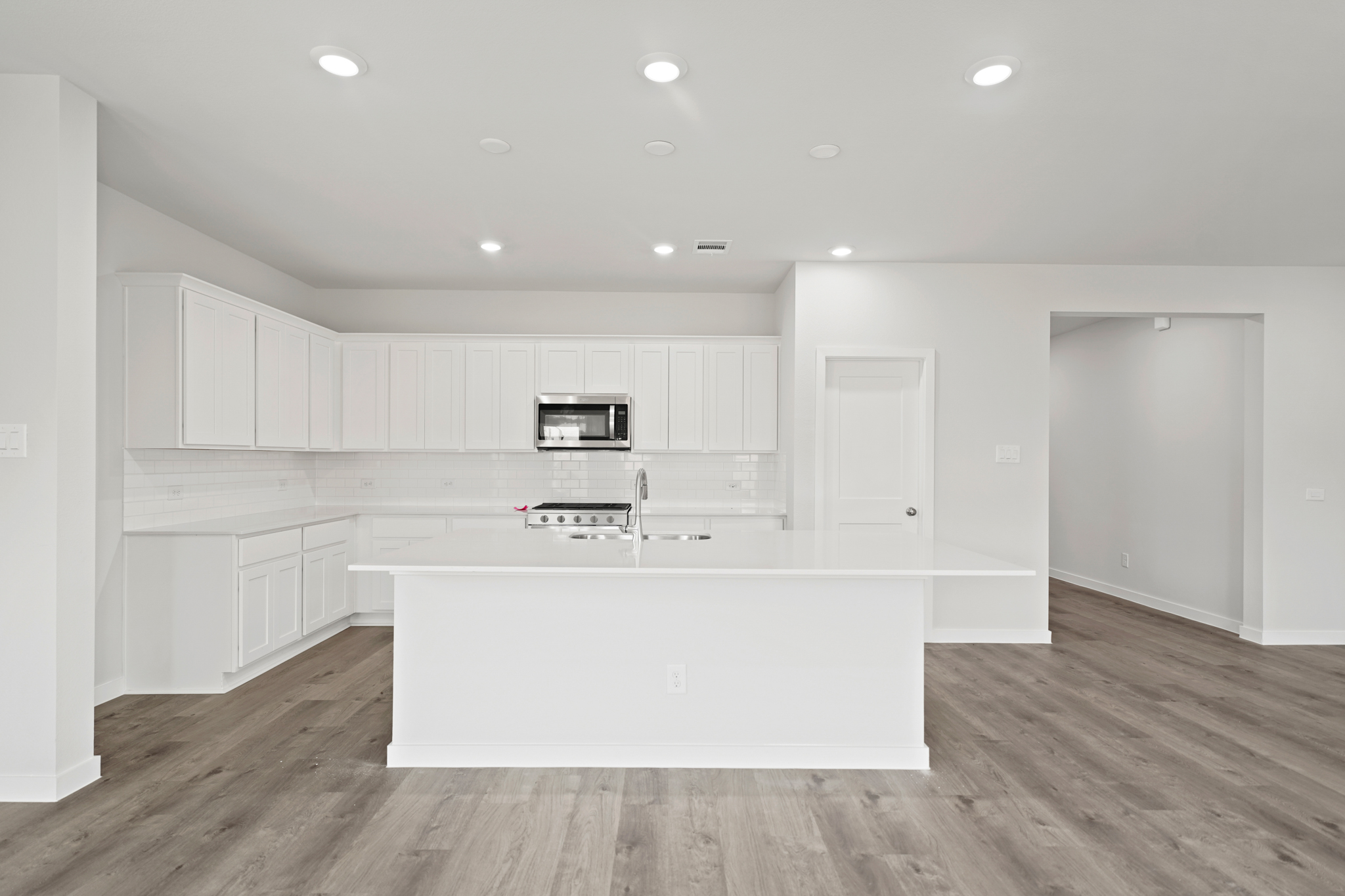 A kitchen with white cabinets.