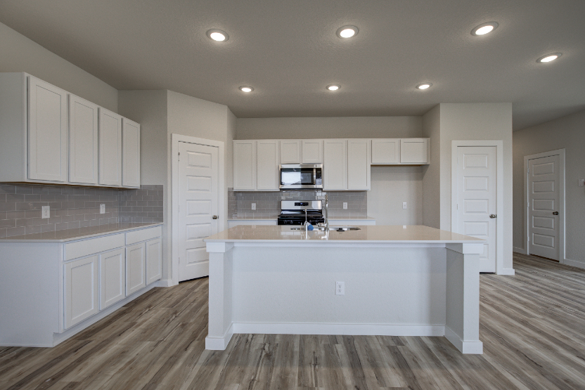 A kitchen with white cabinets.