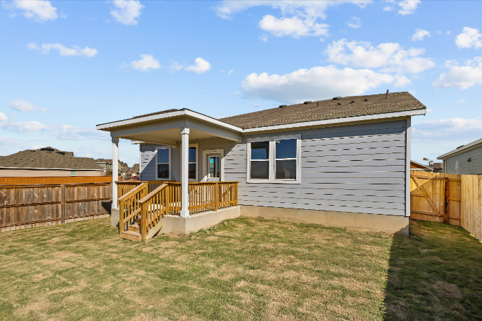 A house with a fence and a yard with a wood fence.