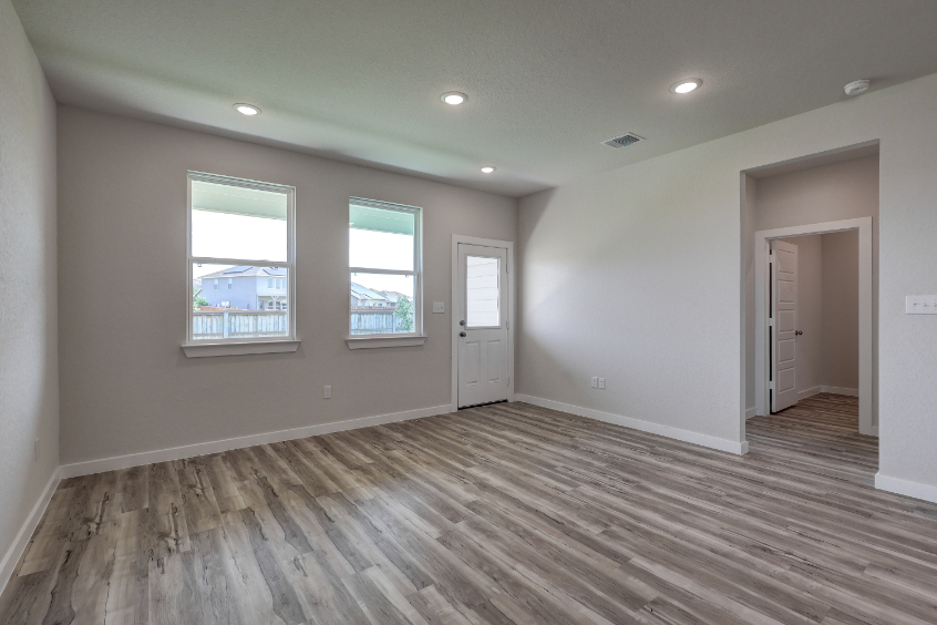 A room with a wood floor and a wood floor with a window.