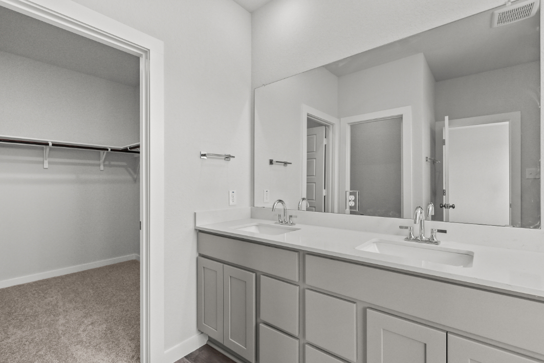 A bathroom with white cabinets.