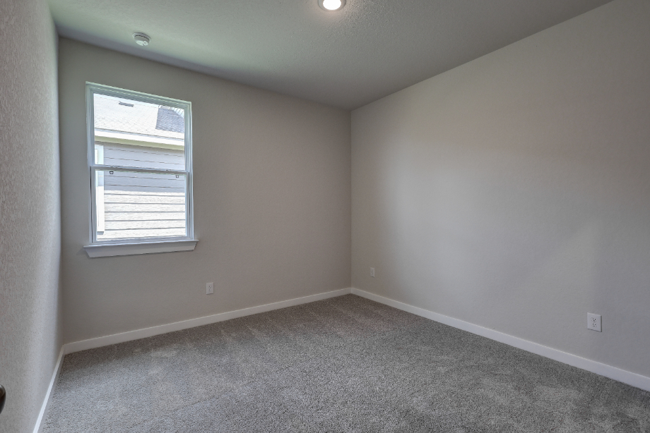 A room with a window and carpet.