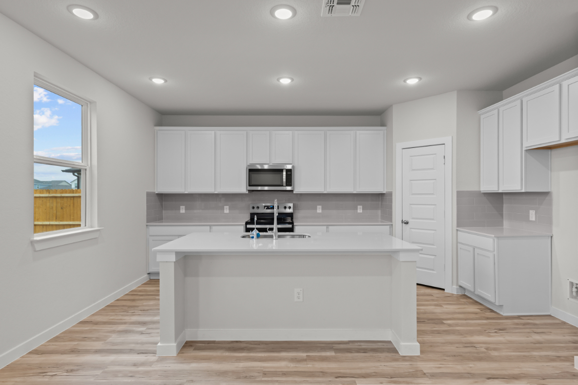 A kitchen with white cabinets.