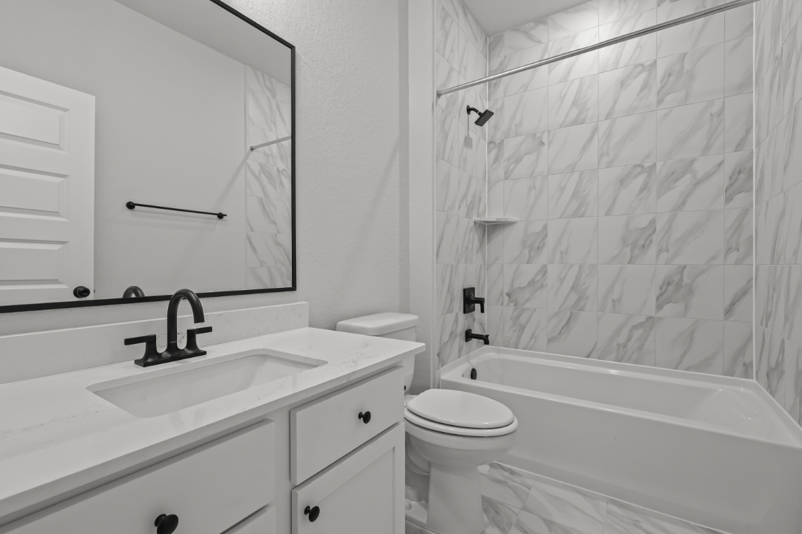 A bathroom with a sink toilet and bathtub.