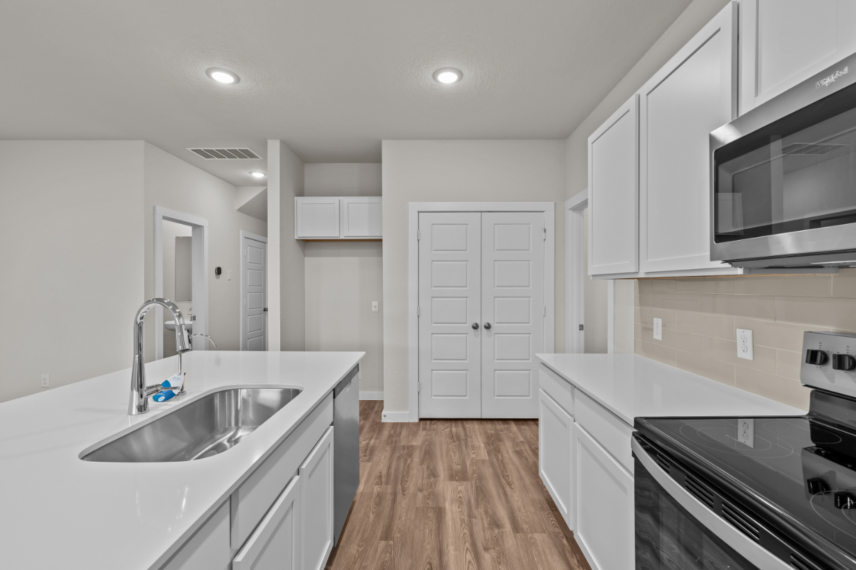 A kitchen with white cabinets.