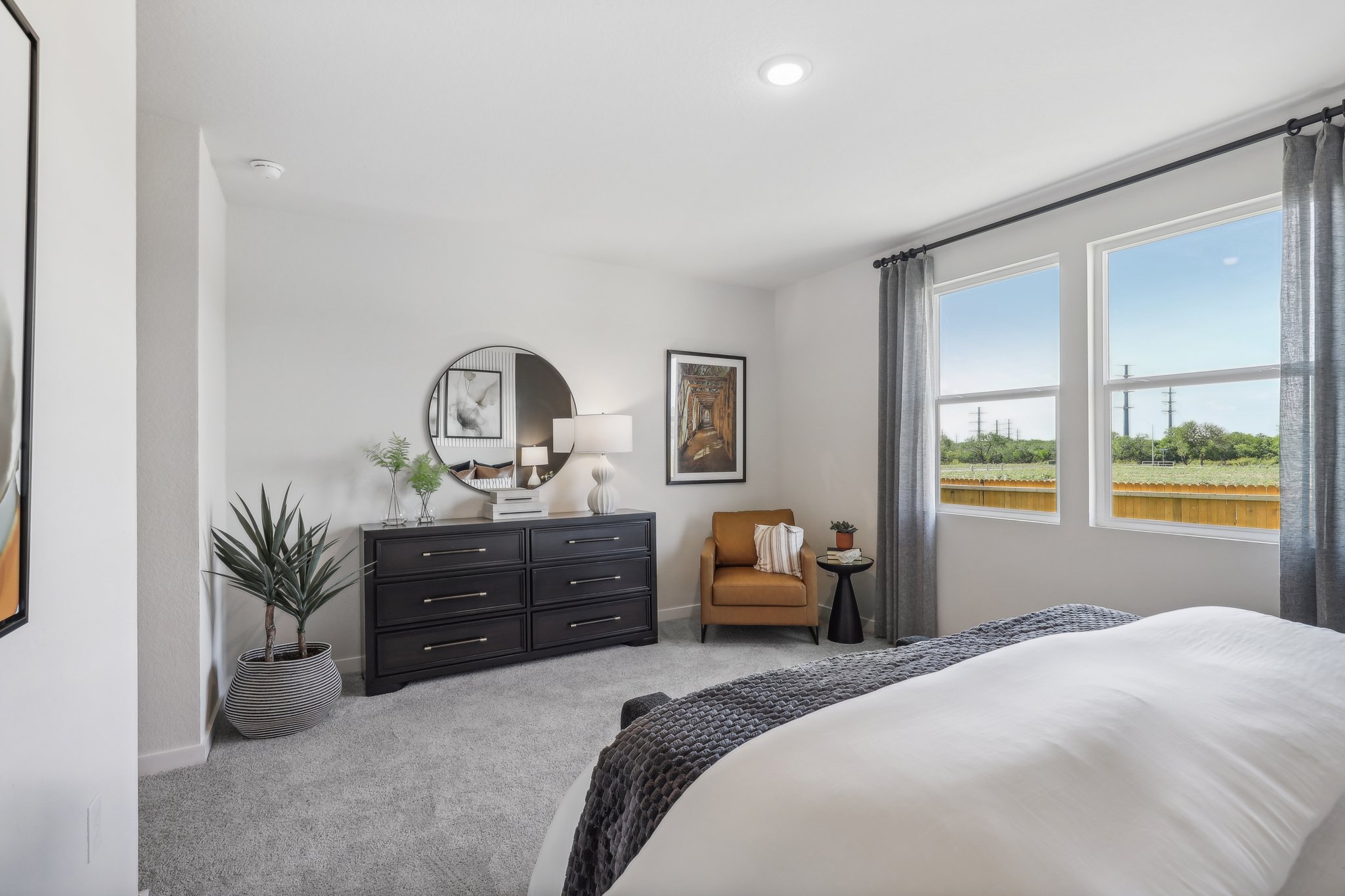 A bedroom with a bed and a mirror.