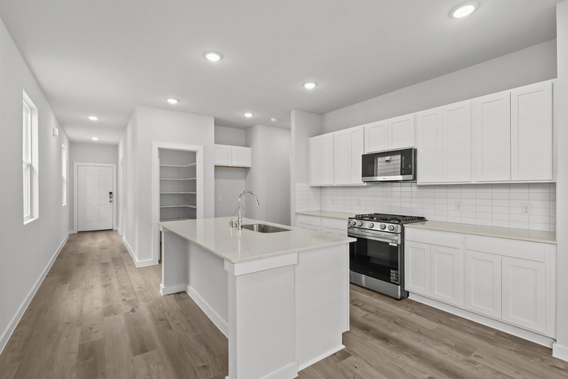 A kitchen with white cabinets.