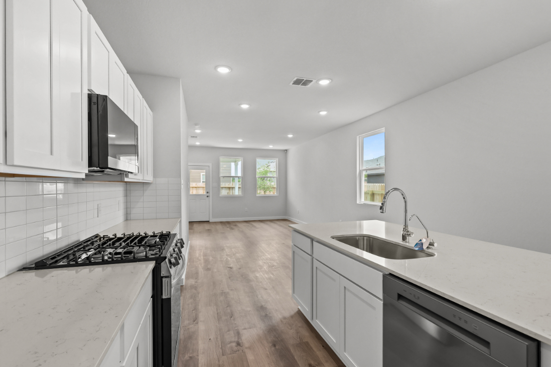 A kitchen with white cabinets.