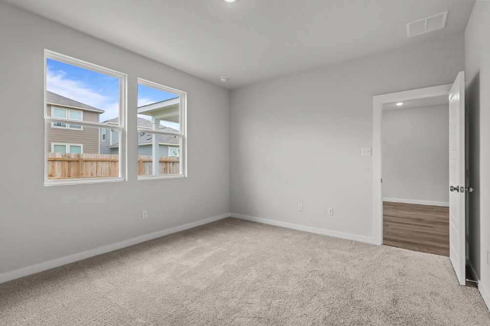 A room with a window and a carpet.
