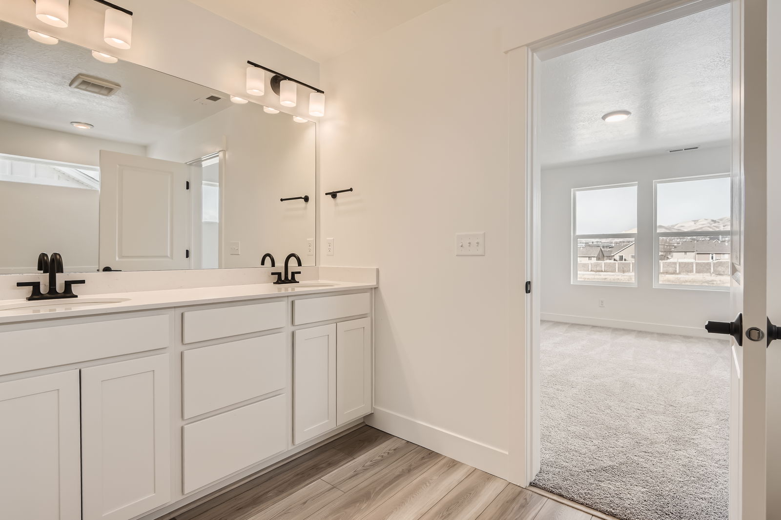 A bathroom with white cabinets.