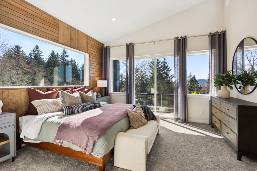 A bedroom with a large window.