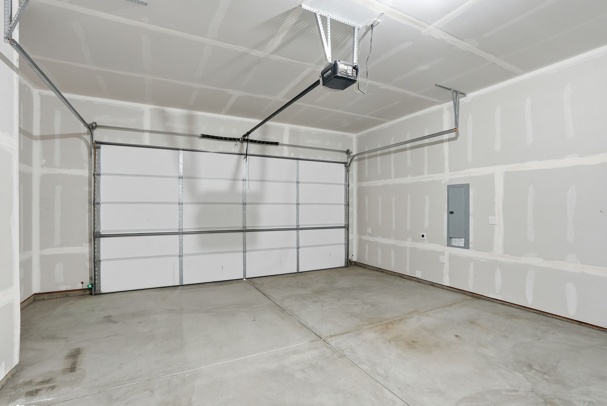 A white tiled room with a white wall and a black wire.