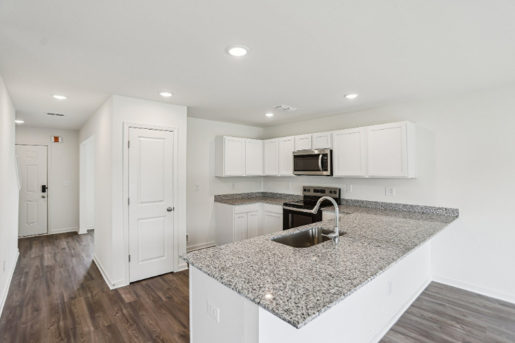 A kitchen with white cabinets.