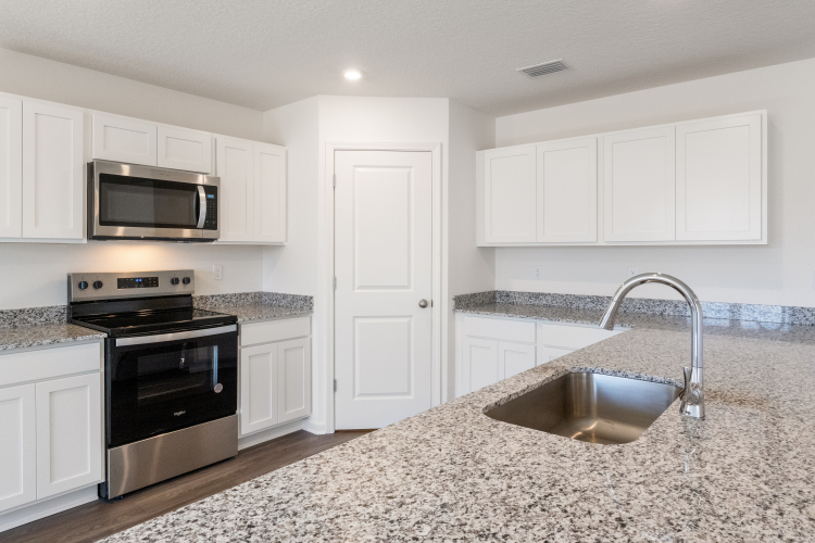 A kitchen with white cabinets.