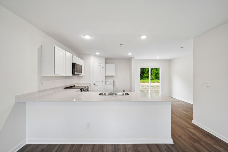 A kitchen with white cabinets.