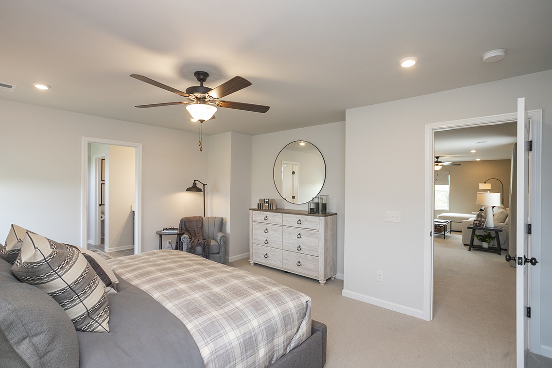 A bedroom with a bed and a fan.