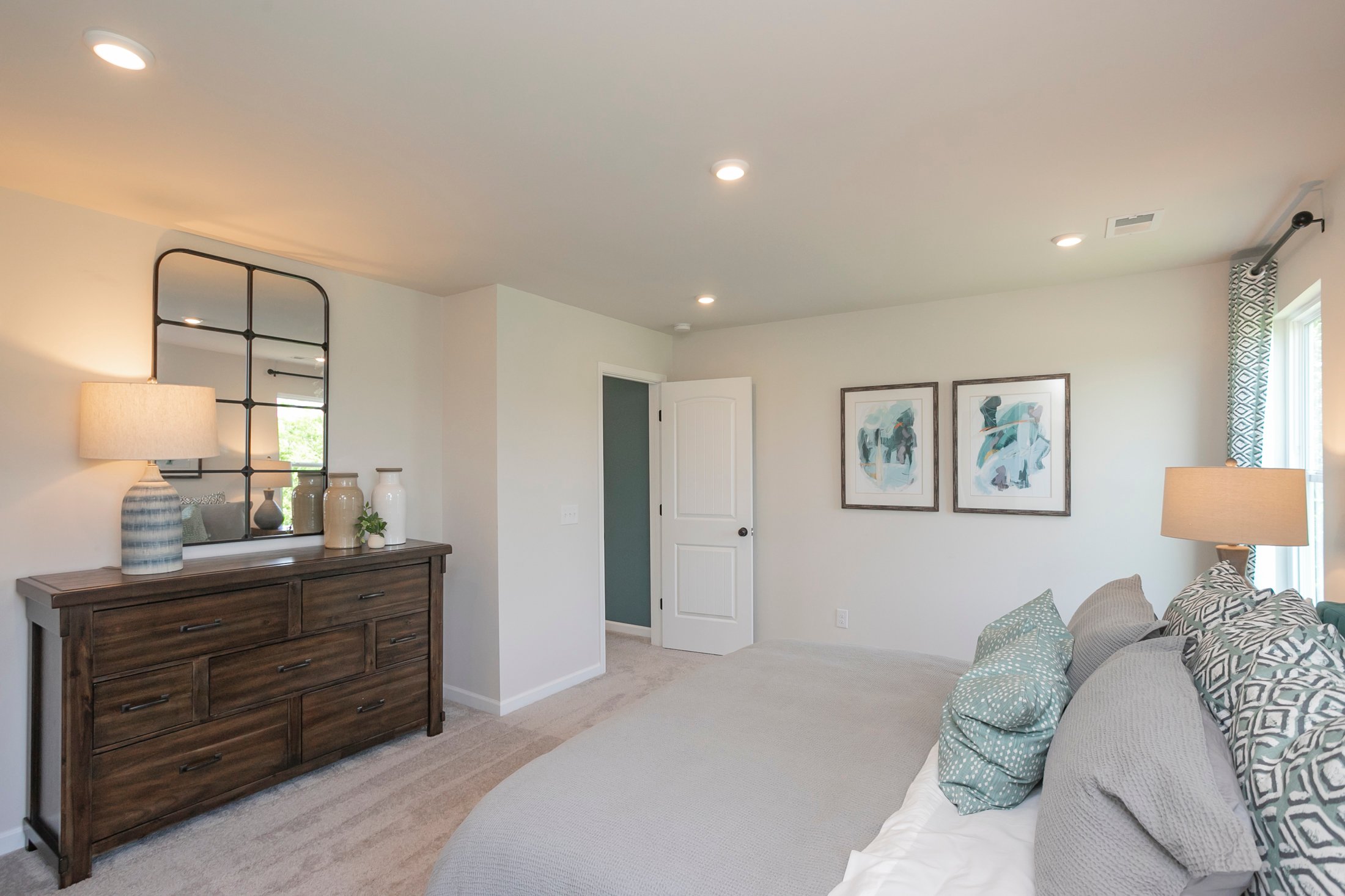 A bedroom with a bed and a dresser.