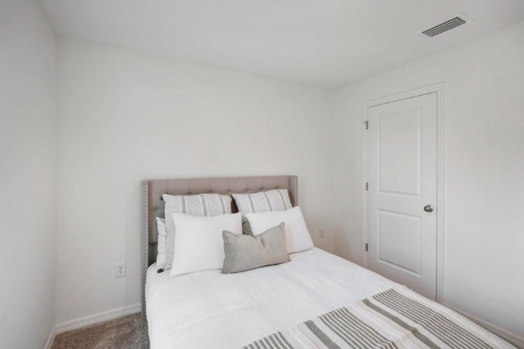 A bed with white sheets.