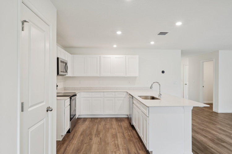 A kitchen with white cabinets.