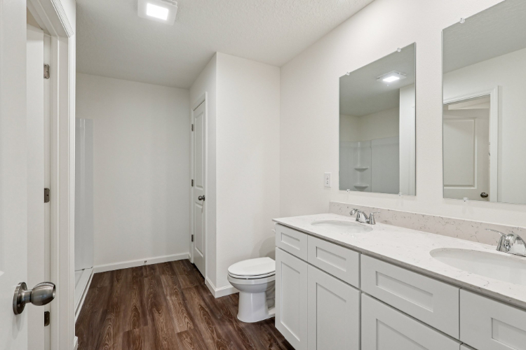 A bathroom with white cabinets.