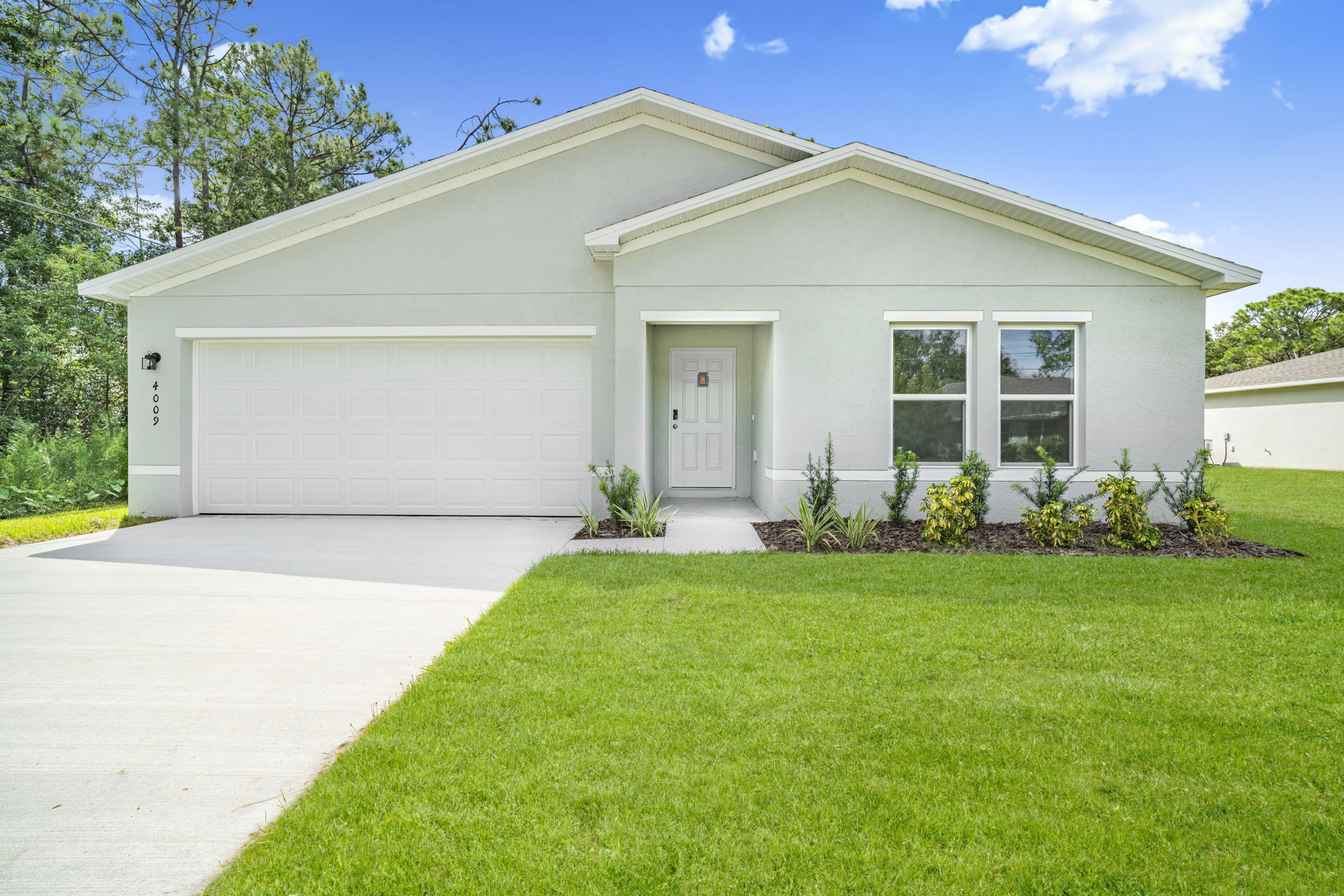 A white house with a lawn.