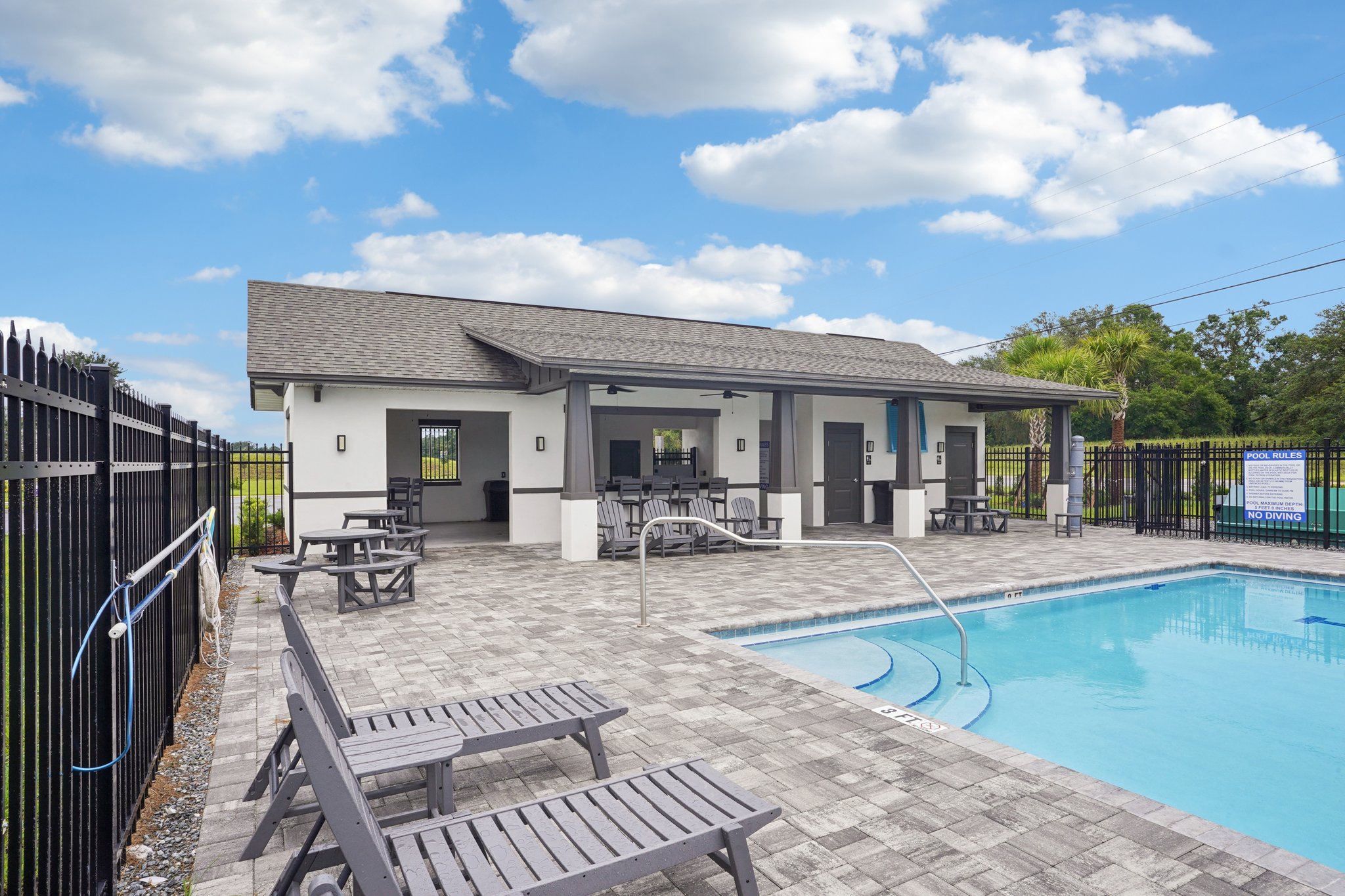 A swimming pool in front of a house.